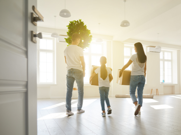 A family carrying boxes out of their house after organizing to sell their home.